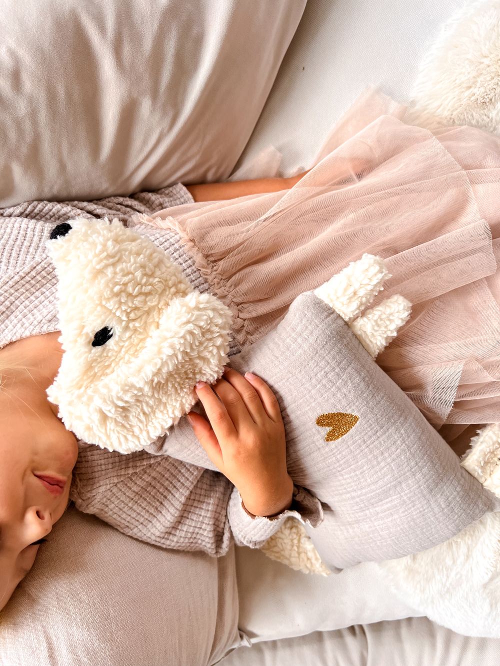 Blondes Mädchen kuschelt sich an ihren Kuschelhund
