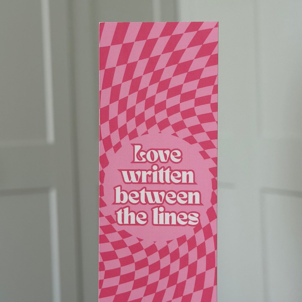 Lesezeichen „Love written between the lines“ mit rosa Karomuster